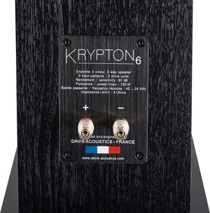 Boxă de podea Davis Acoustics Krypton 6 Technik negru, vedere din spate, placă de identificare dreptunghiulară cu text alb, 2 borne de conexiune circulare aurii și roșii/negre, suprafață texturată cu model de lemn închis la culoare.