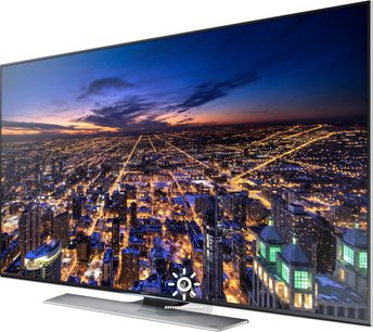 Samsung UE48HU7500 TV viser et natteluftsyn over en oplyst storby med tætpakkede bygninger og skyskrabere