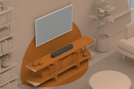 Topvinkel af en sort, rektangulær soundbar i mat plast placeret midt på et lavt møbel i lyst træ foran et vægmonteret tv og flankeret af små dekorative genstande