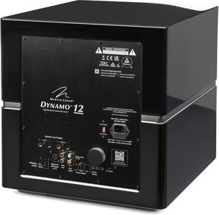 Dynamo 12 subwoofer i sort højglans, set bagfra i vinkel, rektangulært tilslutningspanel med hvide inskriptioner og stik.