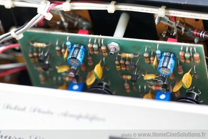 Grønt printplade med farvede elektroniske komponenter, modstande og kondensatorer, tæt på udsigt over indersiden af en elektronisk enhed