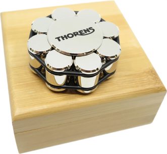 Chrome stabilizer record weight for Thorens turntables, top view, placed on a rectangular light wood box