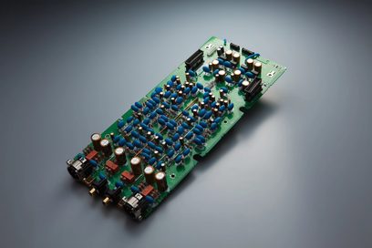 Prostokątna zielona płytka drukowana z niebieskimi i srebrnymi elementami elektronicznymi, widok z góry z bliska