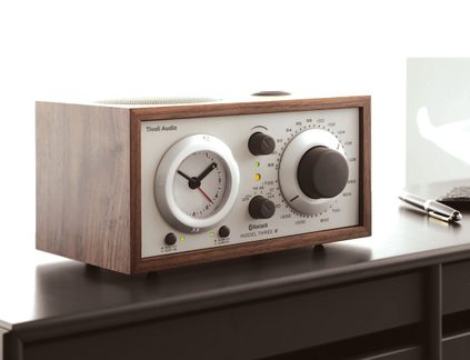 Træradio med vækkeur i brun, hvid front, urskive og stor drejeknap, grønne lysdioder, set fra tre kvart forfra