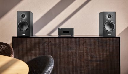 Hi-fi sestava Canton se dvěma černými regálovými reprosoustavami a kompaktním zesilovačem na tmavém dřevěném příborníku