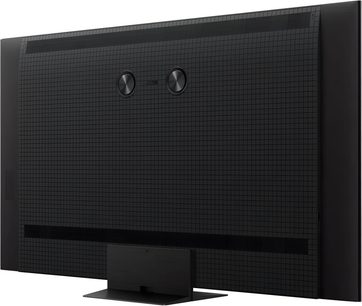 TCL 75C7K High-Definition-Fernseher in schwarzem Kunststoff, Rückseite mit Gitterstruktur, ausgestattet mit zwei zentralen runden Scheiben und einem breiten rechteckigen Standfuß, Rückansicht in Dreiviertelperspektive