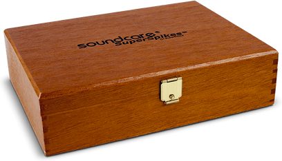 Caixa retangular de madeira fechada com a inscrição "soundcare superspikes" e fecho metálico dourado na frente