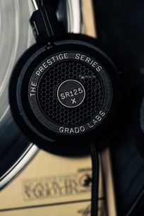 Åben hi-fi hovedtelefon Grado SR125x, sort transducer med heksagonal metalrist, sølvfarvede markeringer på kanten, sort hovedbøjle