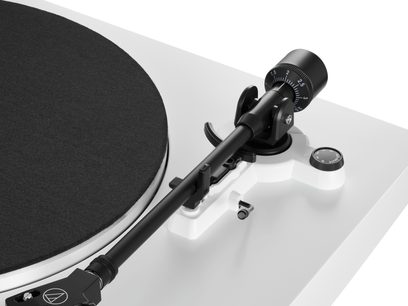 Audio Technica AT-LP3XBT hvid pladespiller set fra siden, sort tonarm med pickup, sort pladespiller, kontroller på siden
