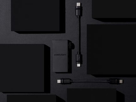 Černé obdélníkové pouzdra, černé kabely, stříbrné konektory, bílý logo "Astell&Kern" na pouzdře, pohled zepředu