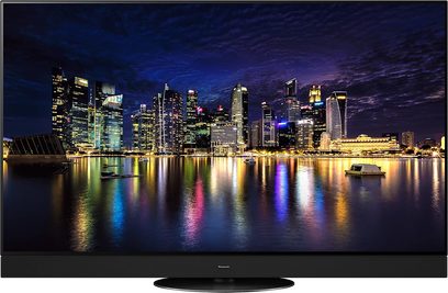 Panasonic TX-55MZ2000E-tv, der viser en by om natten ved vandet med oplyste skyskrabere og farverige refleksioner