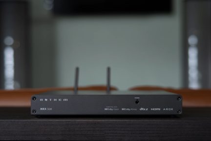 Передня частина прямокутного чорного пристрою з двома антенами, логотипами Dolby Vision, Dolby Atmos, dtsX, HDMI, ARC
