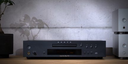 Černý kovový CD přehrávač Onkyo, pohled zepředu, středová šuplíková mechanika, LCD displej, kulatá tlačítka, kolečko a sluchátkový výstup 6,35 mm
