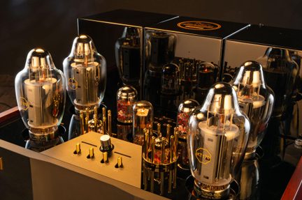 Amplificatore valvolare in metallo nero lucido, grandi valvole in vetro KT170 e manopole dorate, vista ravvicinata