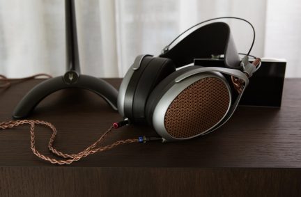 Circumauralt headset med kobberfarvet metalgitter, sort hovedbøjle, brun flettet kabel, sort baggrundsstøtte