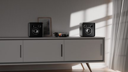 Compacte stereo hifi-keten met twee zwarte luidsprekers op een modern, licht dressoir