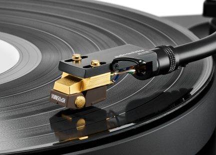 Černá a zlatá přenoska Audio-Technica AT-HS10 v detailním záběru na rotujícím vinylovém disku