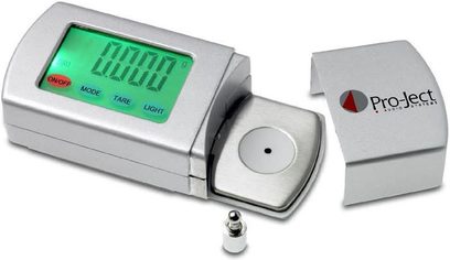 Balança eletrônica Pro-Ject Measure it 2 com tela LCD verde exibindo 0.000, em uma caixa retangular metálica