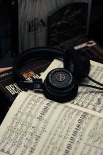 Åben hi-fi hovedtelefon Grado SR225x lagt på nodeark, set ovenfra, sorte skummemoriepuder, hovedbøjle i sort læder