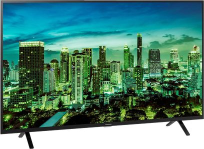 Panasonic TX-43LX700E-fladskærm, der viser et natligt luftfoto af en oplyst by med mange skyskrabere