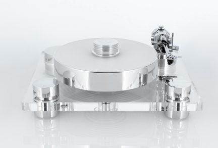 Prato de vinil prateado em metal polido com bandeja circular e prensador central, montado em uma base quadrada de acrílico transparente com quatro pés cilíndricos e braço de leitura lateral direito, vista frontal