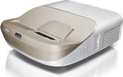 Benq W1600UST hvid og grå videoprojektør, set fra en trekvart forvisning, med linse, gitre og knapper på toppen