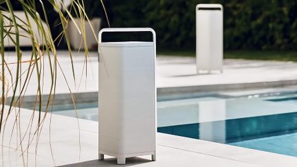 Altoparlante da esterno bianco dal design rettangolare, vista frontale, installato a bordo di una piscina moderna