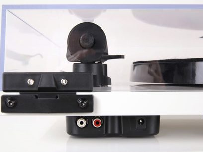 Rega Planar 1 Plus matt vit skivspelare framifrån med tonarm, pickup och reglage i närbild