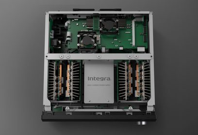 Вътрешен изглед на усилвател за домашен кинотеатър Integra DRX 8.4, показващ зелени печатни платки, електронни компоненти и вентилатори