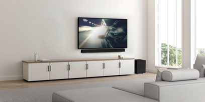 Klipsch Cinema 700 soundbar i sort set forfra, TV-skærm viser en bil der kører med høj hastighed