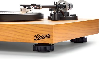 Gramofón Roberts Stylus z svetlého dubového dreva, pohľad z troch štvrtín, čierny tanier, ramienko a tlmiace nožičky