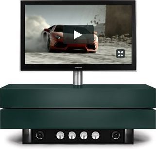Spectral Brick BR1502-SL TV-møbel i mørk grøn, fladskærm, sløret orange sportsvogn i baggrunden