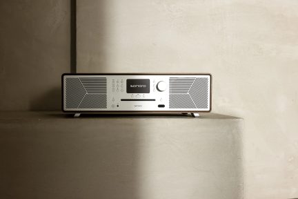 Radio Sonoro Meisterstück set forfra, placeret på en betonoverflade, sidebelysning, beige baggrund