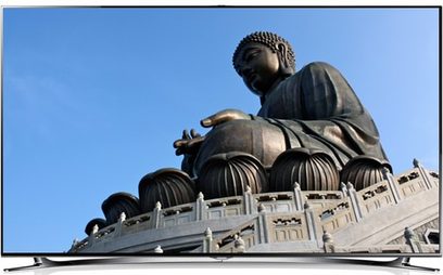 Kæmpe bronzestatue af Buddha siddende i lotusposition på en stor flerniveaus sokkel