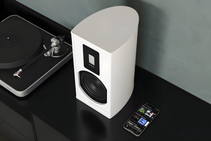 Witte luidspreker, zwarte platenspeler, zwarte smartphone, bovenaanzicht