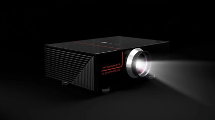 Чорний відеопроєктор SIM2 Superhybrid 25-28, сріблястий об’єктив і світловий промінь, вигляд у три чверті