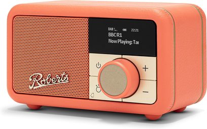 Rádio Roberts Revival Petite 2 v oranžové barvě, pouzdro z umělé kůže, přední panel s perforovaným grilováním v laděné barvě s logem, černý obdélníkový digitální displej, velký kruhový ovládací knoflík v béžovo-zlaté barvě a čtyři čtvercová tlačítka, pohled z pravého předního tříčtvrtečního úhlu