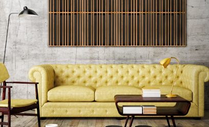 Üç kişilik hardal sarısı Chesterfield tarzı kanepe, altın renkli masa lambası, ahşap sehpa, dikey ahşap şeritlerden oluşan duvar paneli