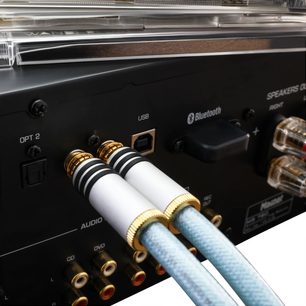 Oehlbach Series 2 analogt RCA-lydkabel 2 m lyseblå, flettet nylonkappe, hvide cylindriske metalstik med dobbelt sort ring og guldbelagte kontakter, nærbillede fra siden med tilsluttede stik