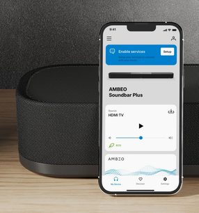 Zvuková lišta Sennheiser AMBEO Soundbar Plus v černé barvě a mobilní aplikace pro nastavení na smartphonu s bílou obrazovkou