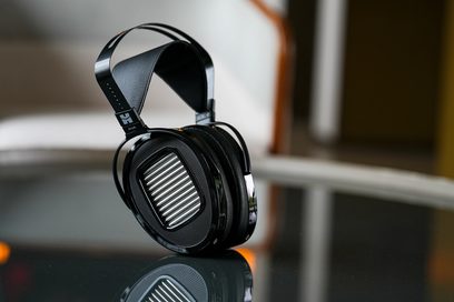Sluchátka Hifiman Arya s otevřenou konstrukcí, oválné černé náušníky s kovovou mřížkou, perforovaný oblouk, odrazný povrch