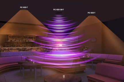 Vedere interioară a unui spațiu cu canapele roz, mese rotunde din lemn, bar în fundal, lumină violetă în spirală în centru