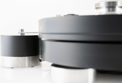 Transrotor Max Nero RB880 hi-fi vinylplatespiller i matt sort og børstet aluminium, nærbilde fra siden som viser den tykke tallerkenen, den sylindriske motorblokken og de metalliske føttene