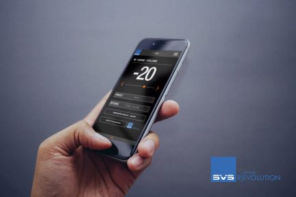 Smartphone grigio con schermo tattile che mostra un'interfaccia di controllo audio, tenuto in mano, sfondo grigio uniforme