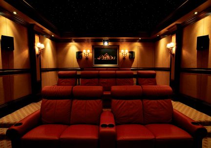 Privates Heimkino mit braunen Ledersesseln, Wandbeleuchtung, zentralem Bildschirm, Sternenhimmel-Decke, Frontalansicht
