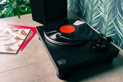 Audio Technica AT-LP5X sort pladespiller, tæt ovenfra-billede, med en rød vinylplade på tallerkenen