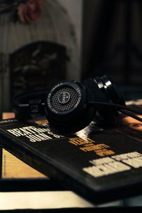 Grado SR225x åbne hi-fi-hovedtelefoner i sort, placeret på bøger, set fra trekvart vinkel forfra, nærbillede
