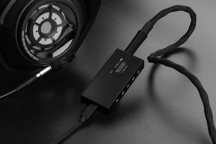 Căști hi-fi Sennheiser deschise, cu transductor la vedere, conectate la un DAC audio USB portabil negru cu ecran OLED