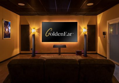 Sorte GoldenEar Triton Reference gulvhøjtalere i et privat hjemmebioanlæg med orange-gule vægge