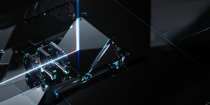 Vedere oblică de aproape a unor prisme triunghiulare și lentile plate din sticlă transparentă cu reflexii albastru-cyan, montate pe o bază neagră și traversate de un fascicul laser alb-albastru
